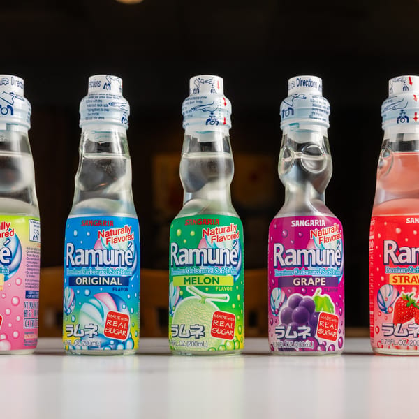 Five colorful bottles of Ramune, a Japanese carbonated soft drink, in various flavors.