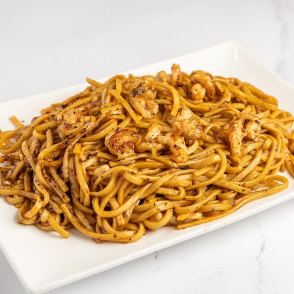 A white rectangular plate filled with Jojo Japanese Hibachi & Sushi's shrimp hibachi noodles.